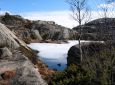 Fjord mit gefrorenem Wasser umgeben von kahlen Felsen. (Norwegen)